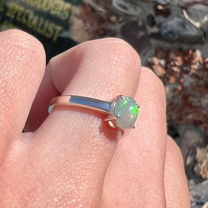 A silver, prong set, oval cabochon cut Ethiopian opal solitaire ring.