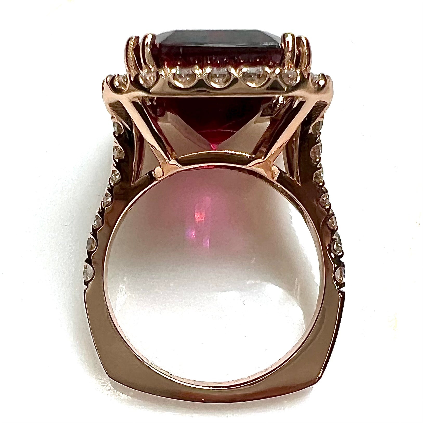 Red emerald cut rubellite tourmaline gemstone set with near flawless round cut diamonds in rose gold.
