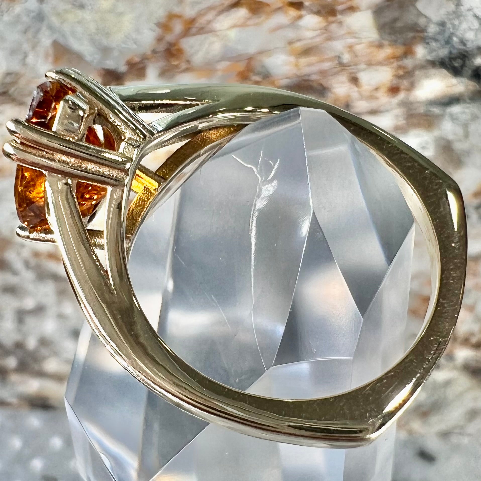 A gold split Euro shank solitaire ring set with an orange pear shape hessonite garnet stone.