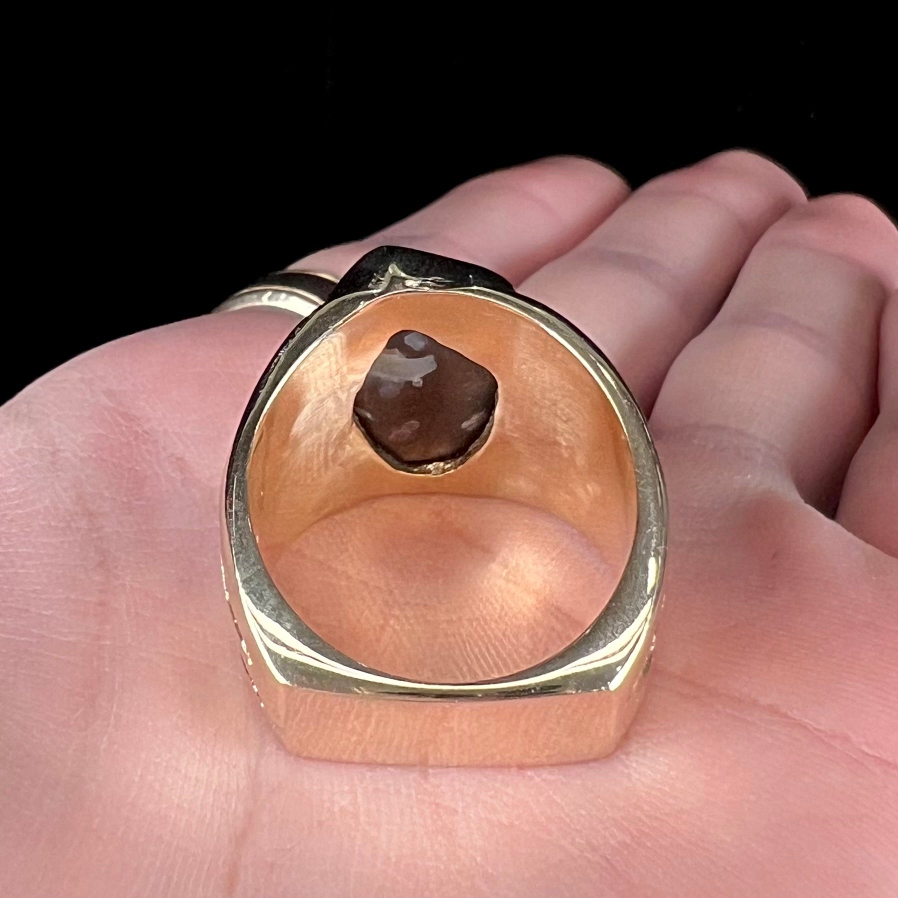 A men's yellow gold fire agate solitaire ring.  The stone has a botryoidal pattern with sagenite inclusions.