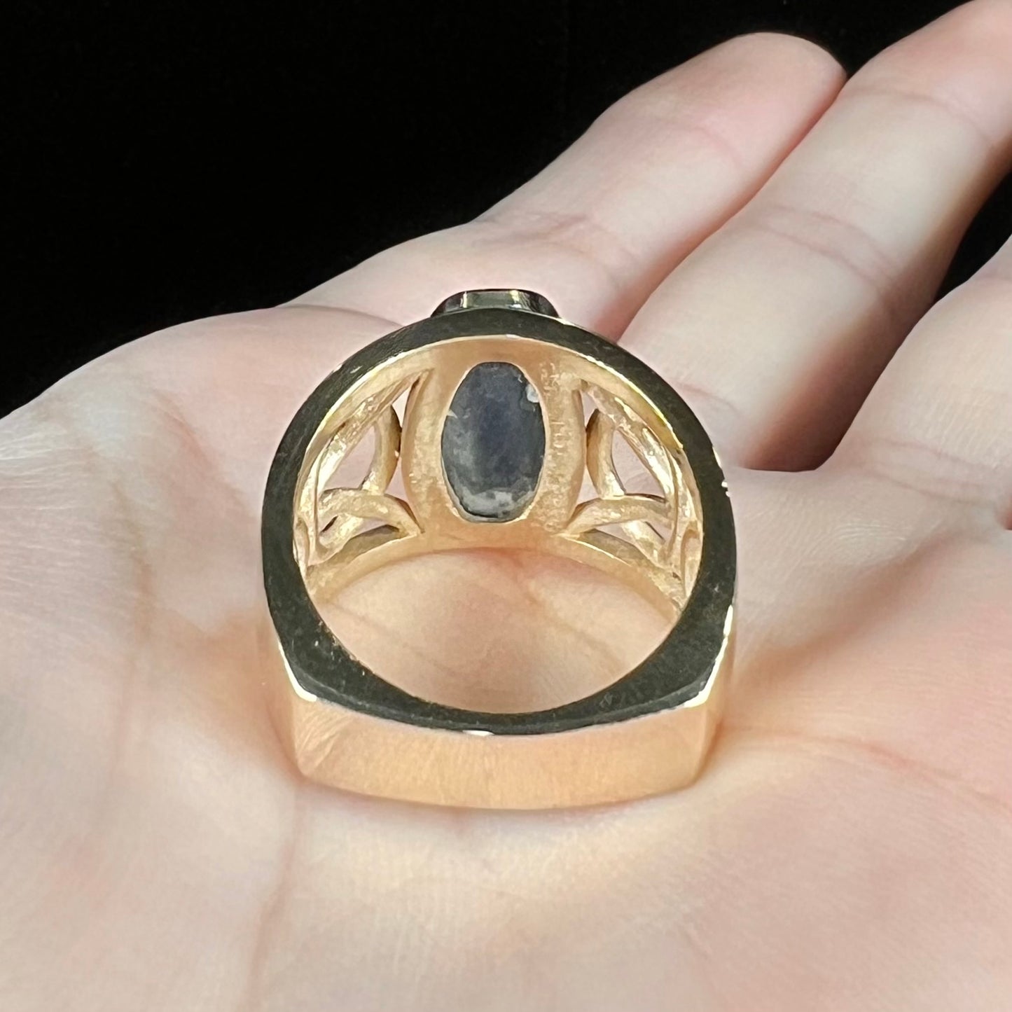 A men's natural Lightning Ridge, Australian black opal solitaire ring cast in yellow gold.