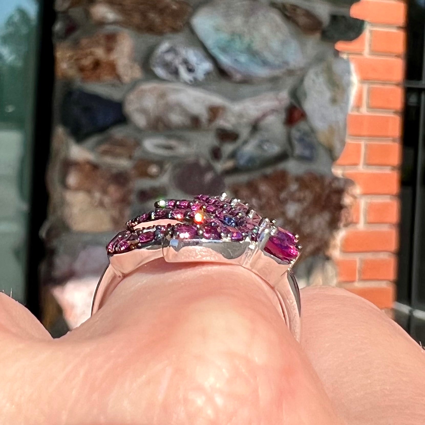A sterling silver, feather shaped ring set with round and marquise cut rhodolite garnet stones.