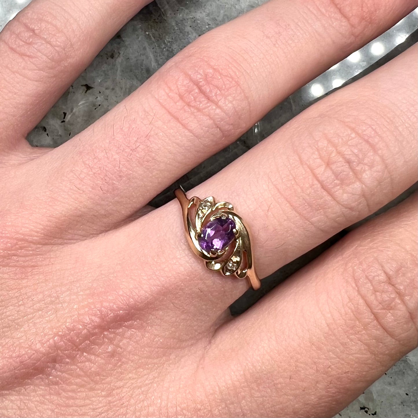 A yellow gold oval cut amethyst and diamond accent ladies' ring.