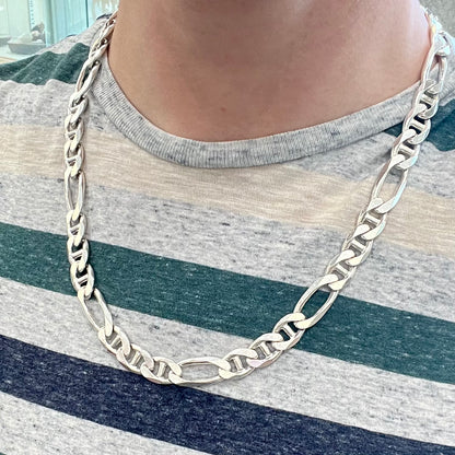 A men's sterling silver figaro anchor chain.  The chain measures 22 inches in length and the links are 11mm wide.