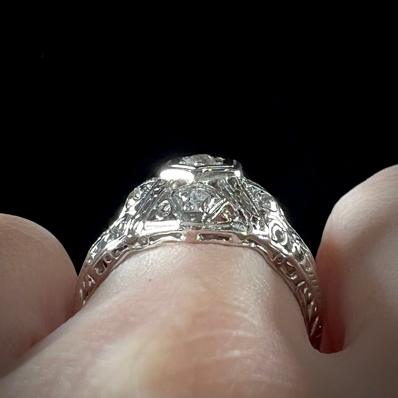 An antique ladies' platinum diamond filigree engagement ring.  The center stone is an old European cut diamond.