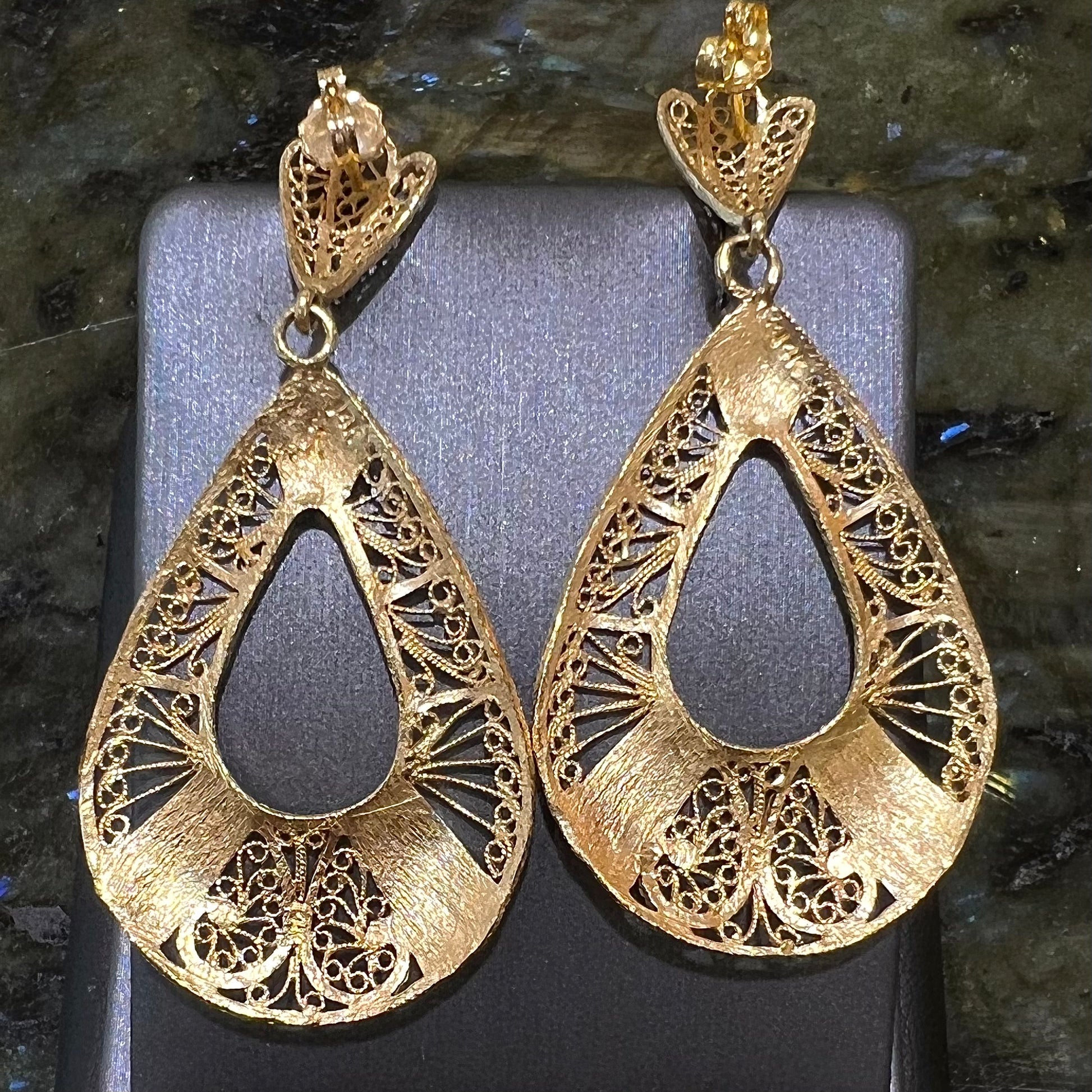 A pair of 14kt yellow gold filigree dangle earrings.  The earrings have a pear shape open design.