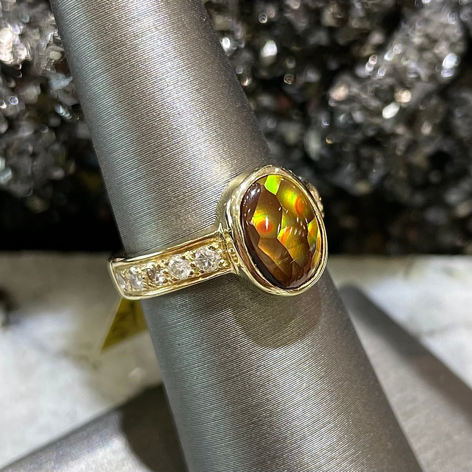 A ladies' oval cabochon cut fire agate and diamond engagement ring cast in yellow gold.