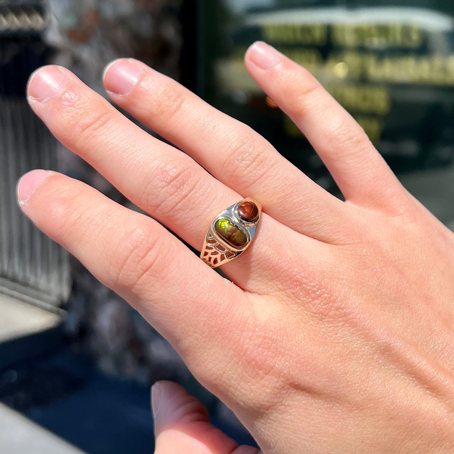 A ladies' yellow gold ring set with two fire agate stones: one green, and one red.