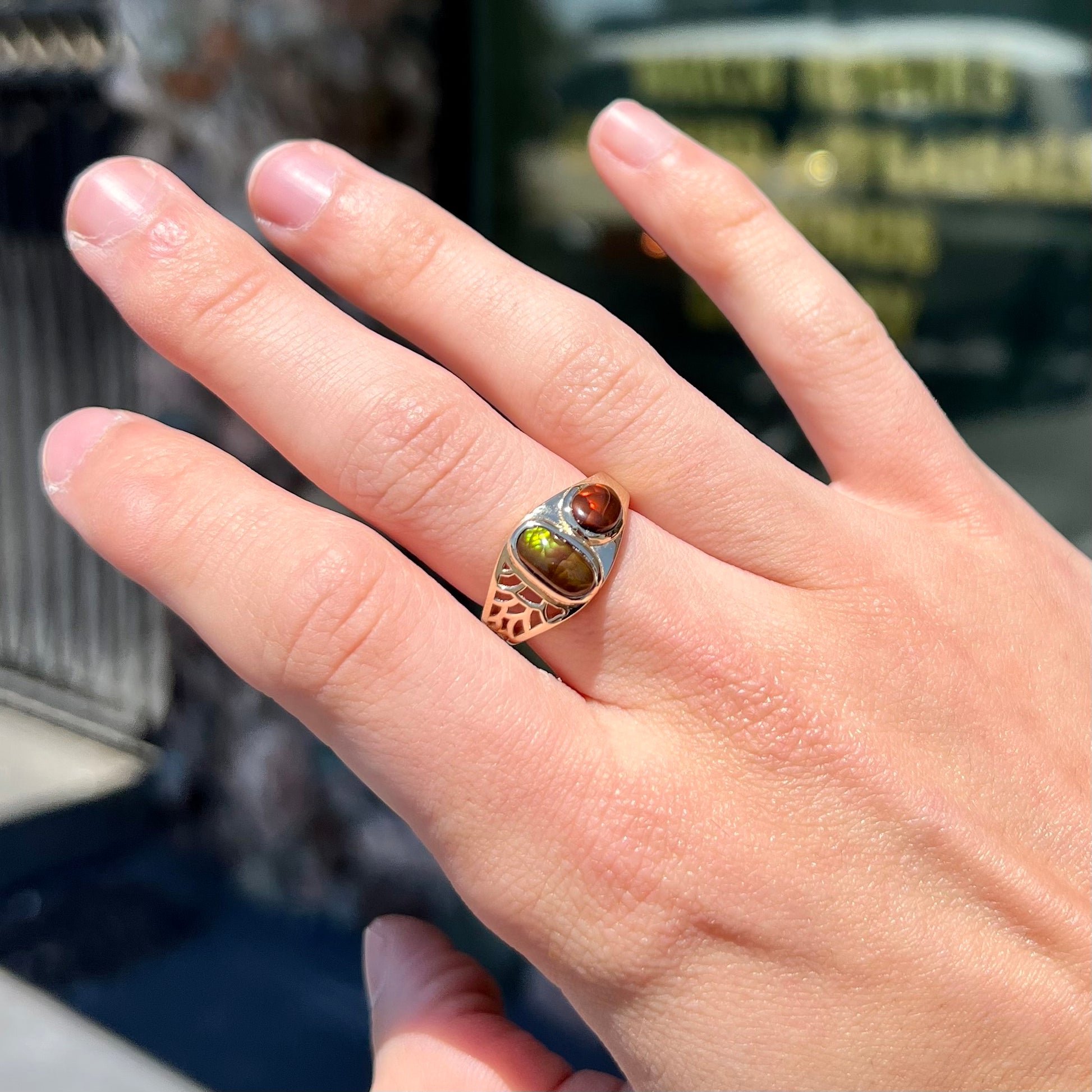 A ladies' yellow gold ring set with two fire agate stones: one green, and one red.