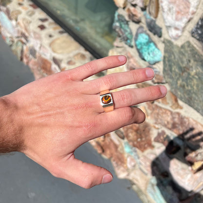 A men's yellow gold flush set fire agate solitaire ring.  The fire agate displays flashes of green, orange, and yellow.