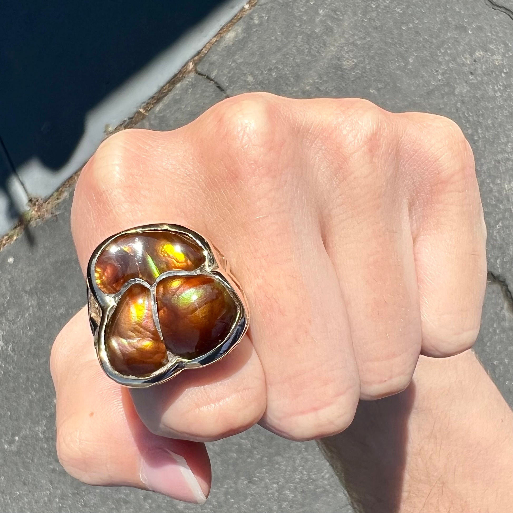 A men's yellow gold ring inlaid with three freeform cut fire agate stones.