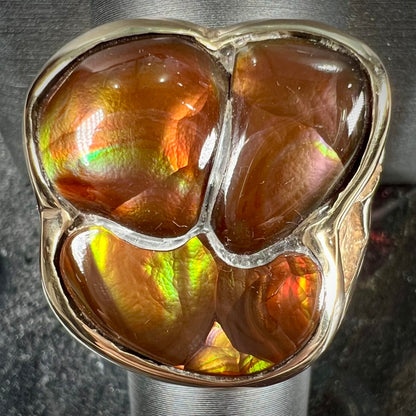 A men's yellow gold ring inlaid with three freeform cut fire agate stones.