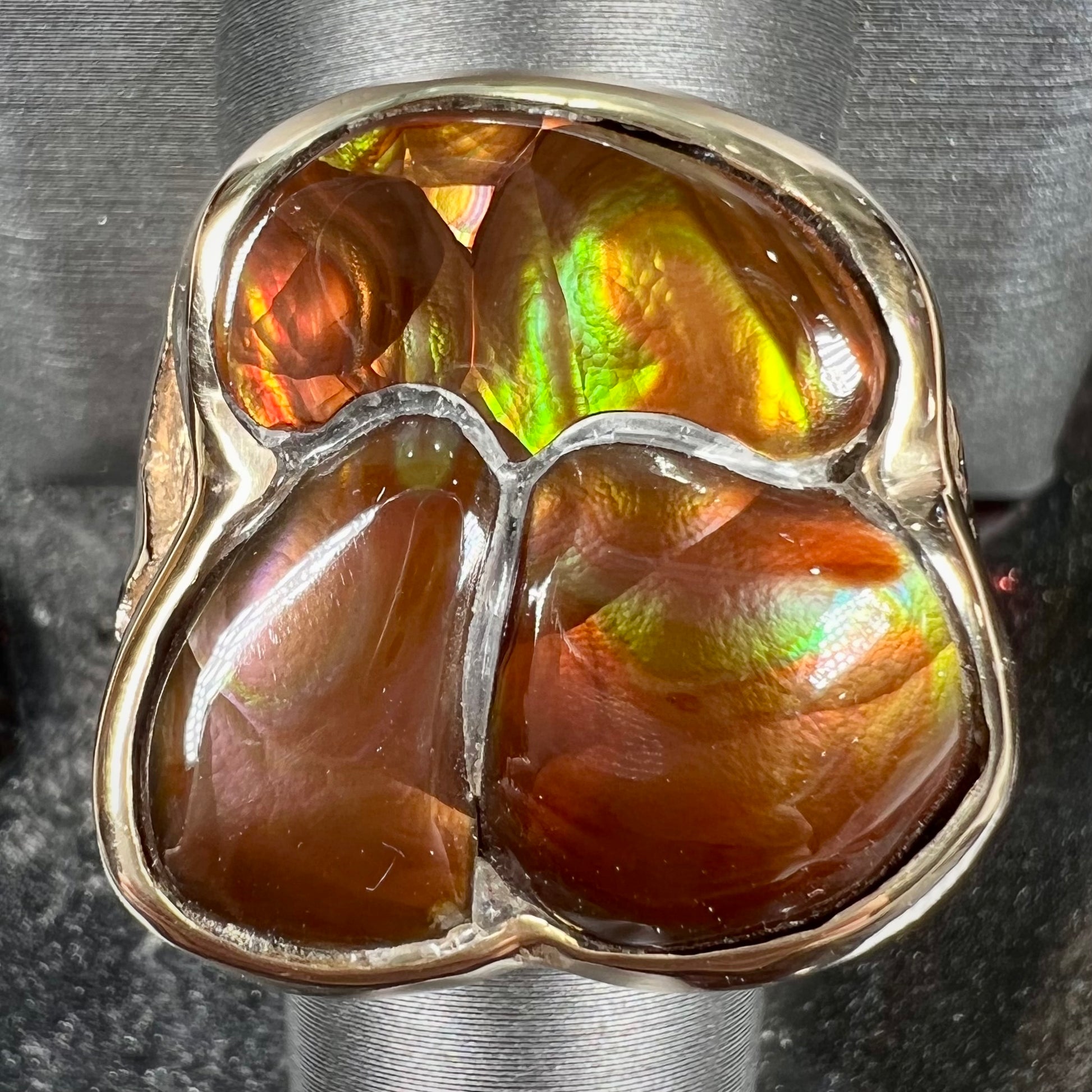 A men's yellow gold ring inlaid with three freeform cut fire agate stones.