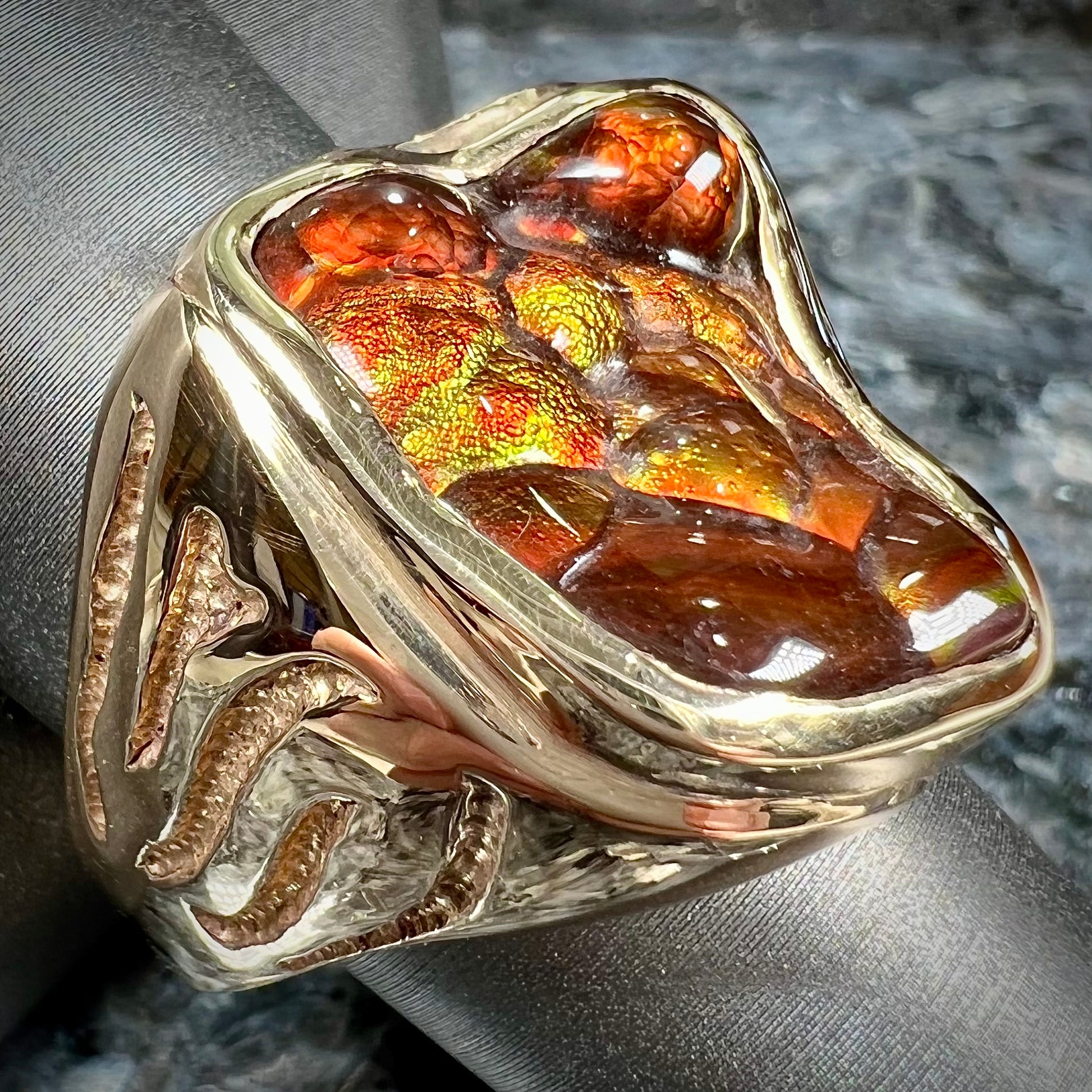 A men's custom fire agate solitaire ring cast in yellow gold.