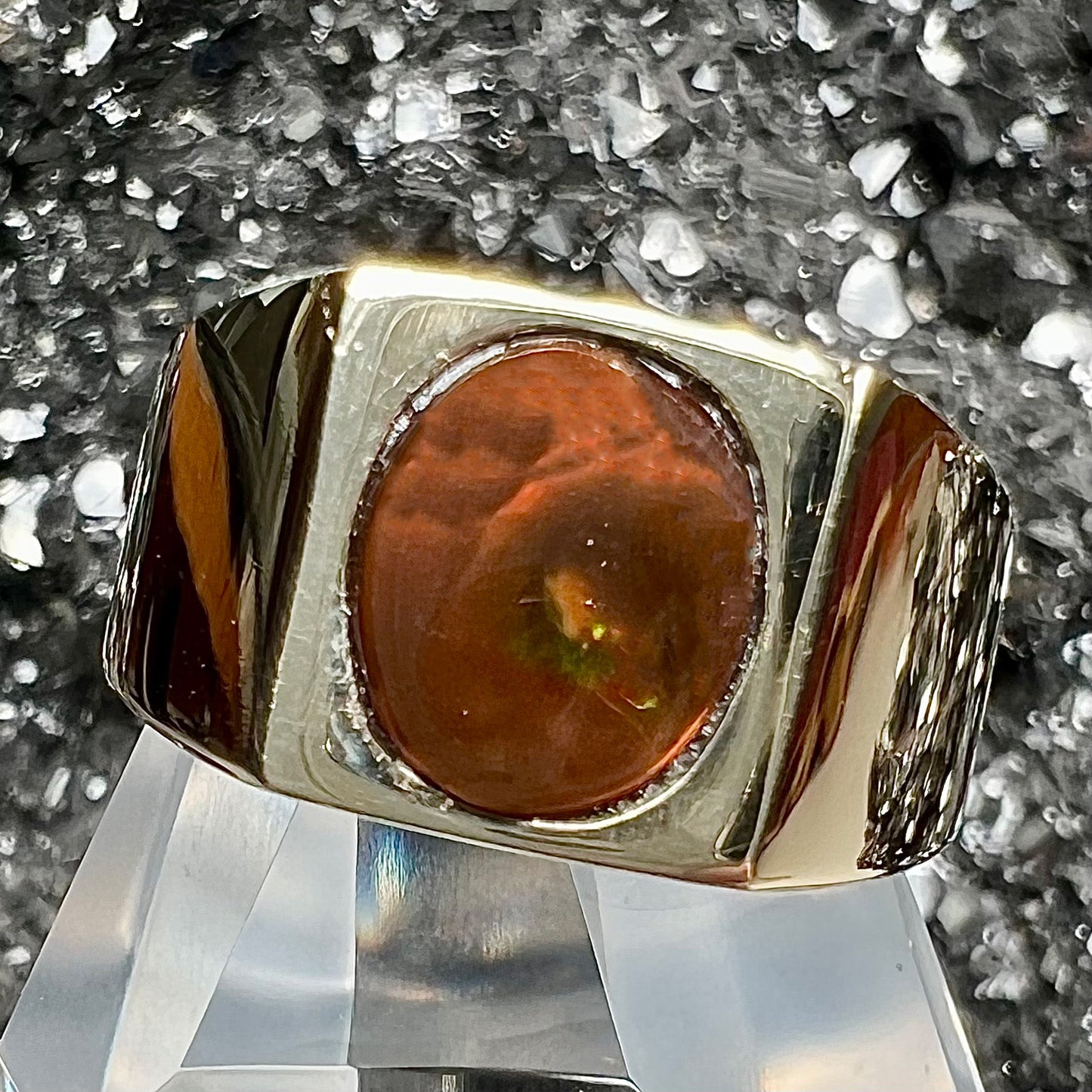 A men's yellow gold flush set fire agate solitaire ring.  The fire agate displays flashes of green, orange, and yellow.