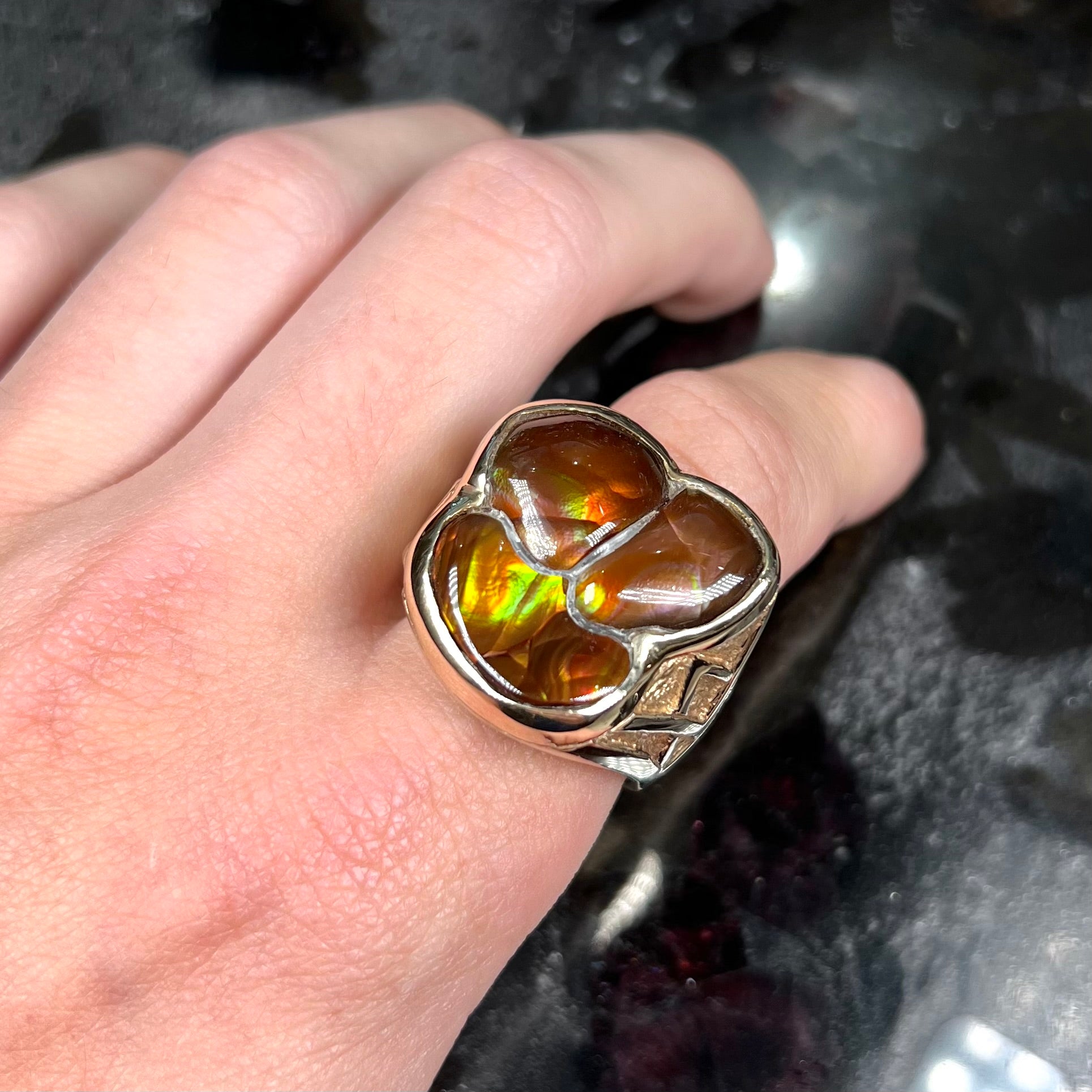 A men's yellow gold ring inlaid with three freeform cut fire agate stones.
