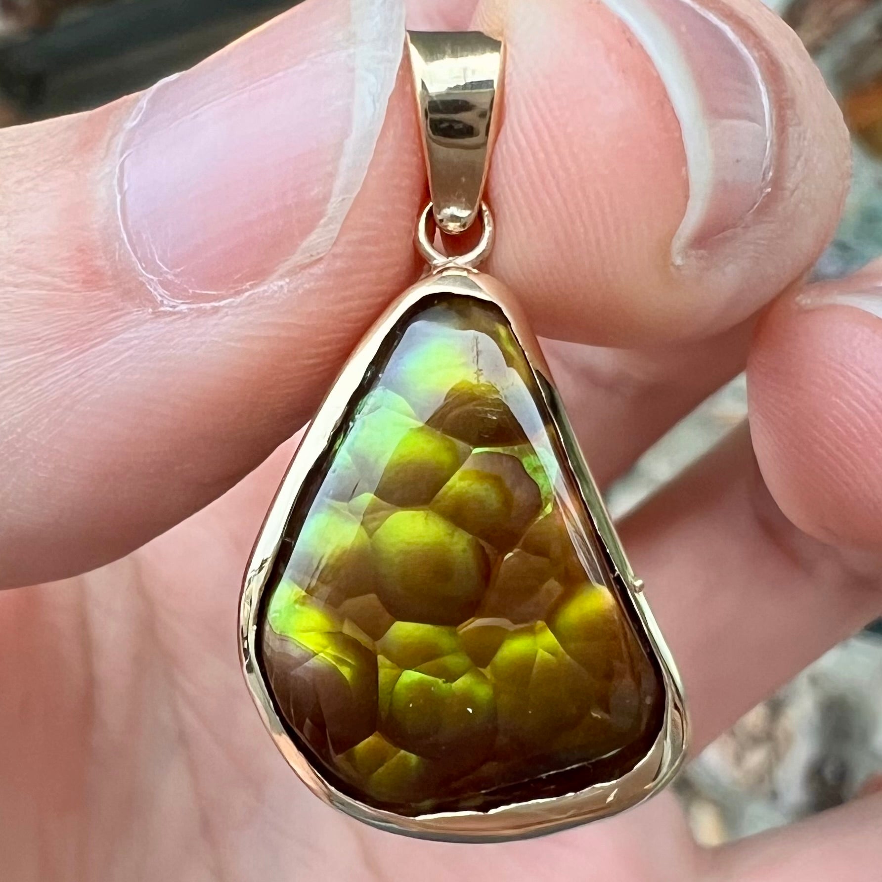 A handmade yellow gold solitaire pendant set with a green fire agate stone from Mexico.