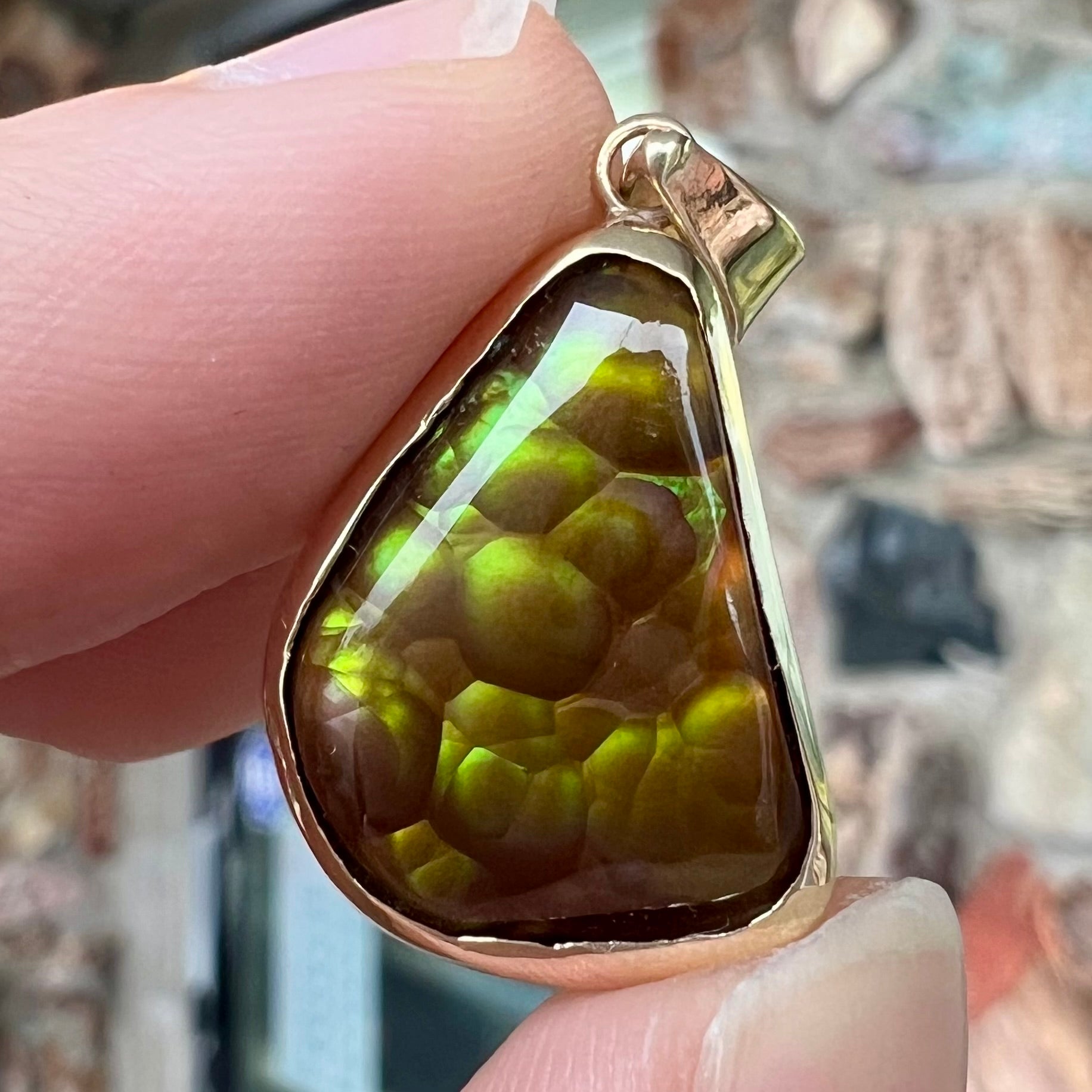 A handmade yellow gold solitaire pendant set with a green fire agate stone from Mexico.