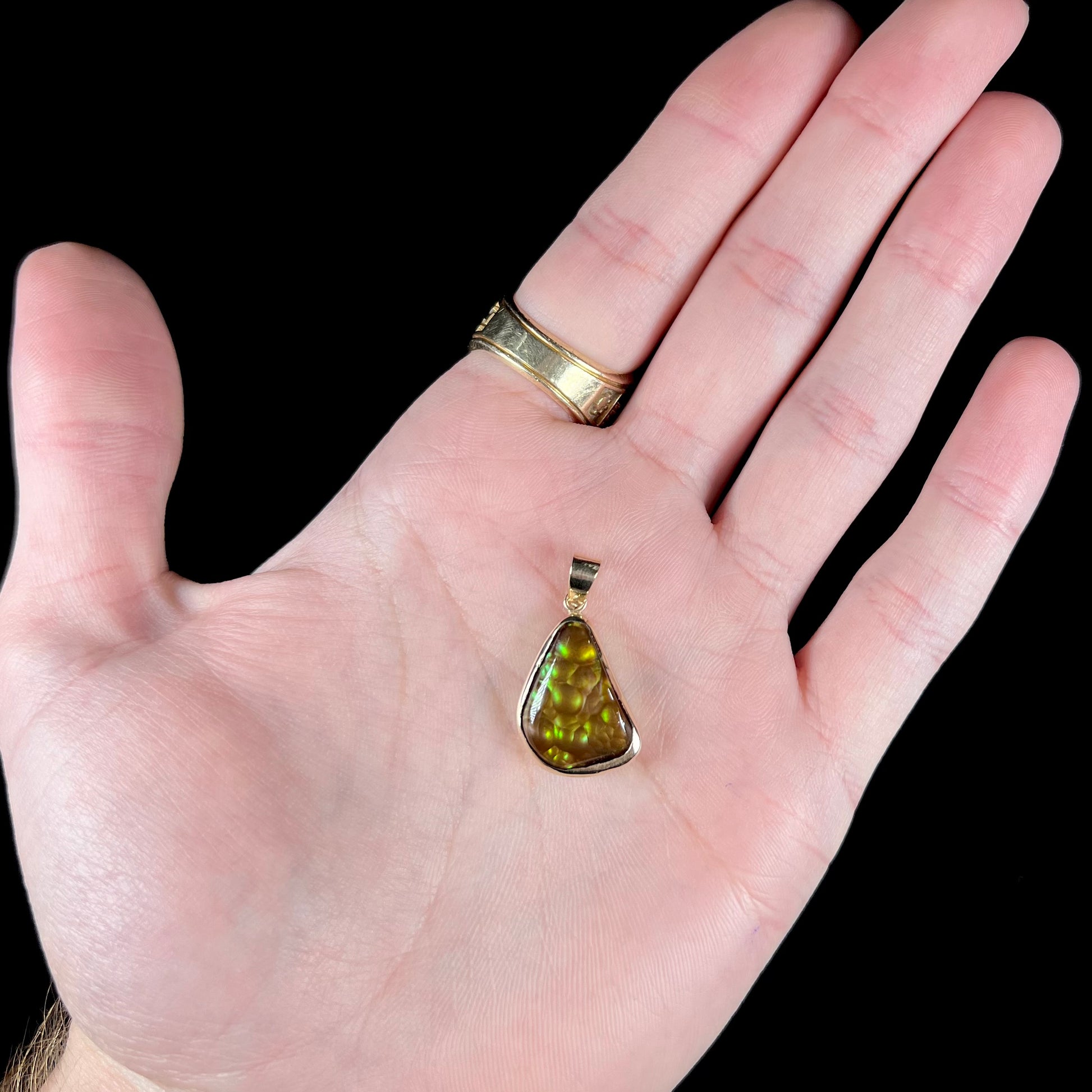 A handmade yellow gold solitaire pendant set with a green fire agate stone from Mexico.