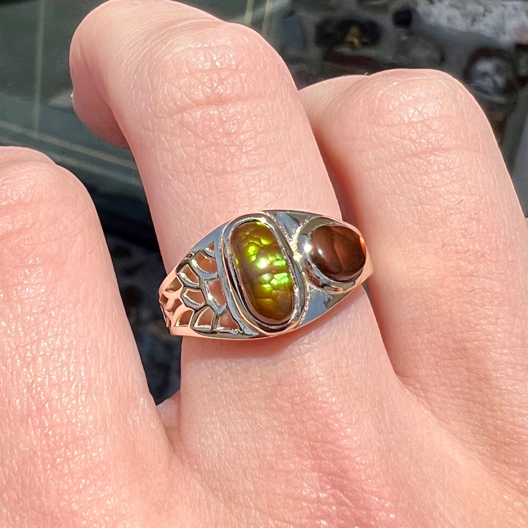 A ladies' yellow gold ring set with two fire agate stones: one green, and one red.
