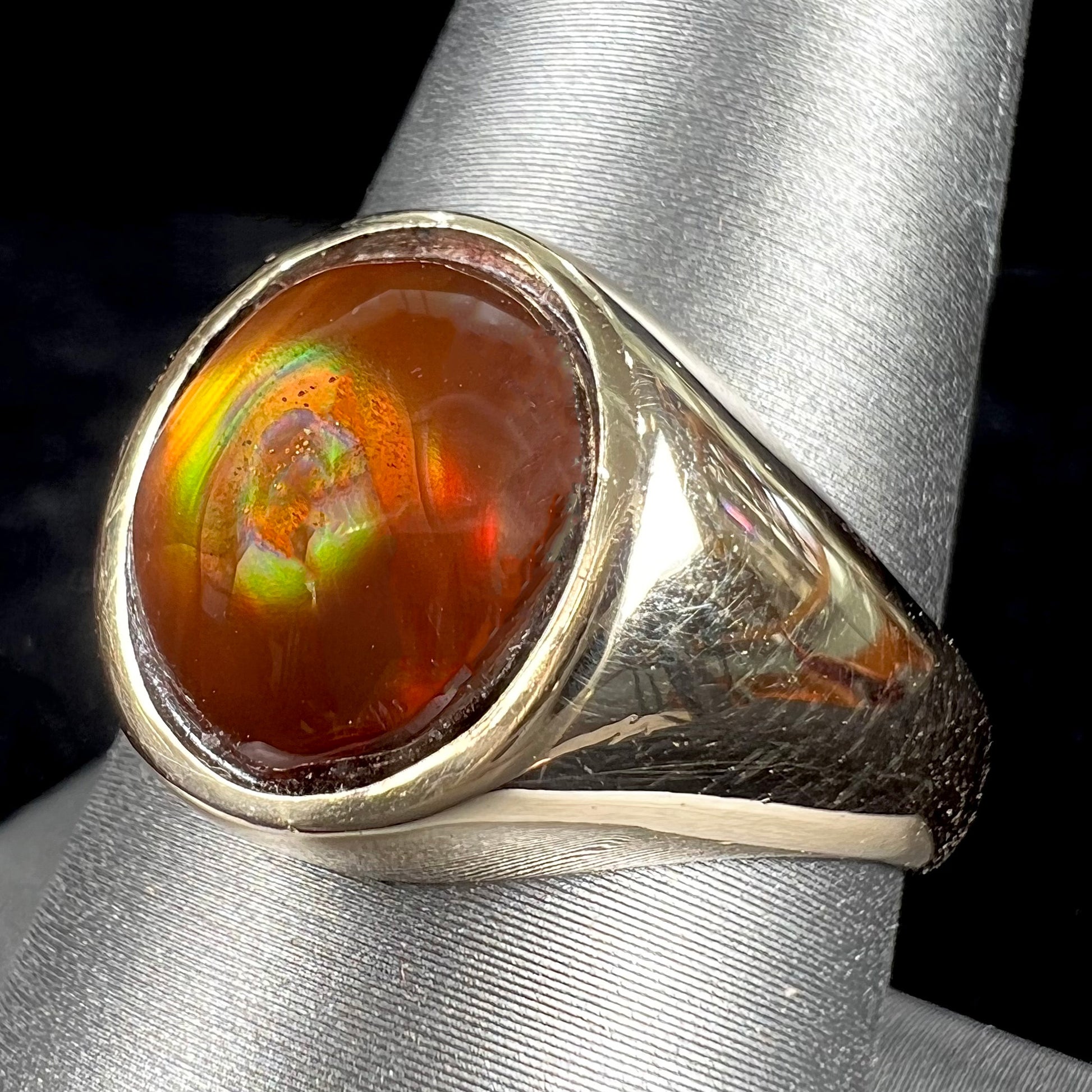 A unisex yellow gold flush set fire agate solitaire ring.