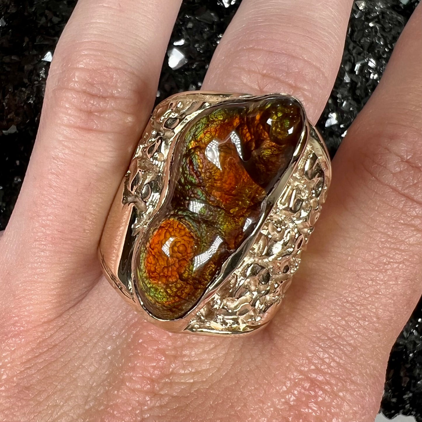 A large nugget style men's fire agate ring cast in yellow gold.  The fire agate is predominantly orange and green.