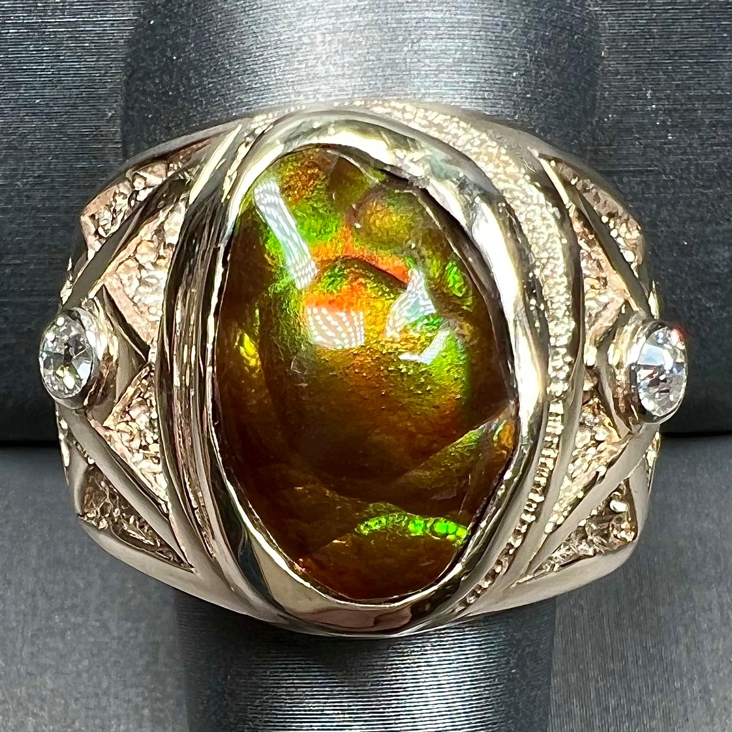 A men's solid yellow gold fire agate and diamond ring.  The fire agate displays predominantly red and green.