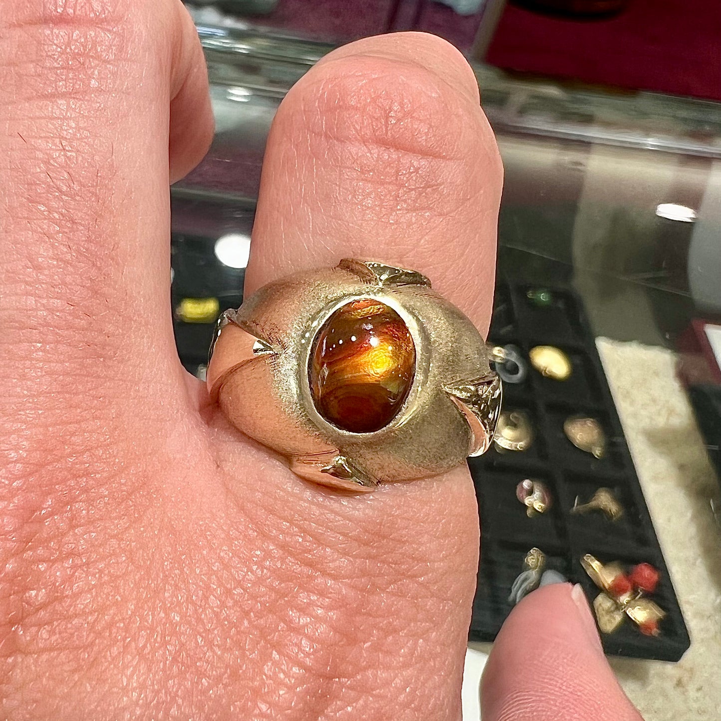 A men's brushed yellow gold fire agate ring with polished accents.