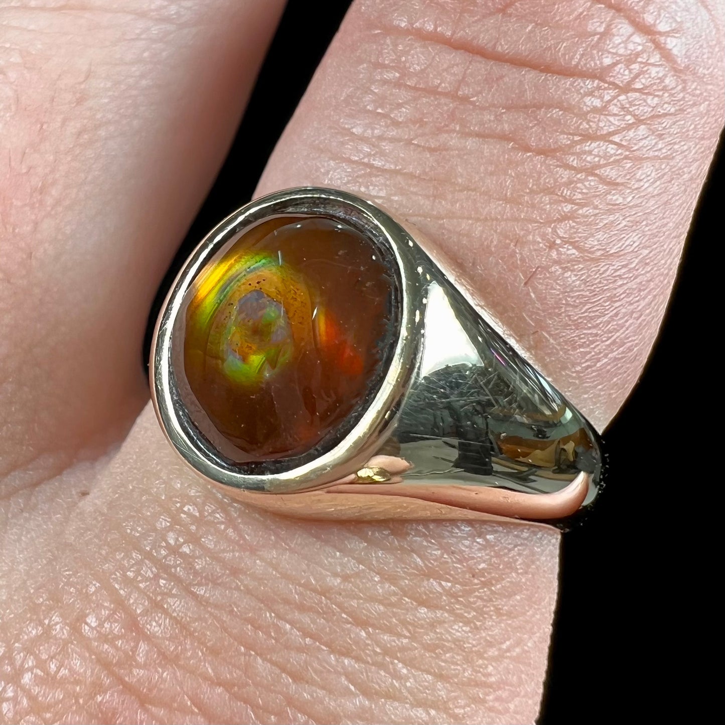 A unisex yellow gold flush set fire agate solitaire ring.