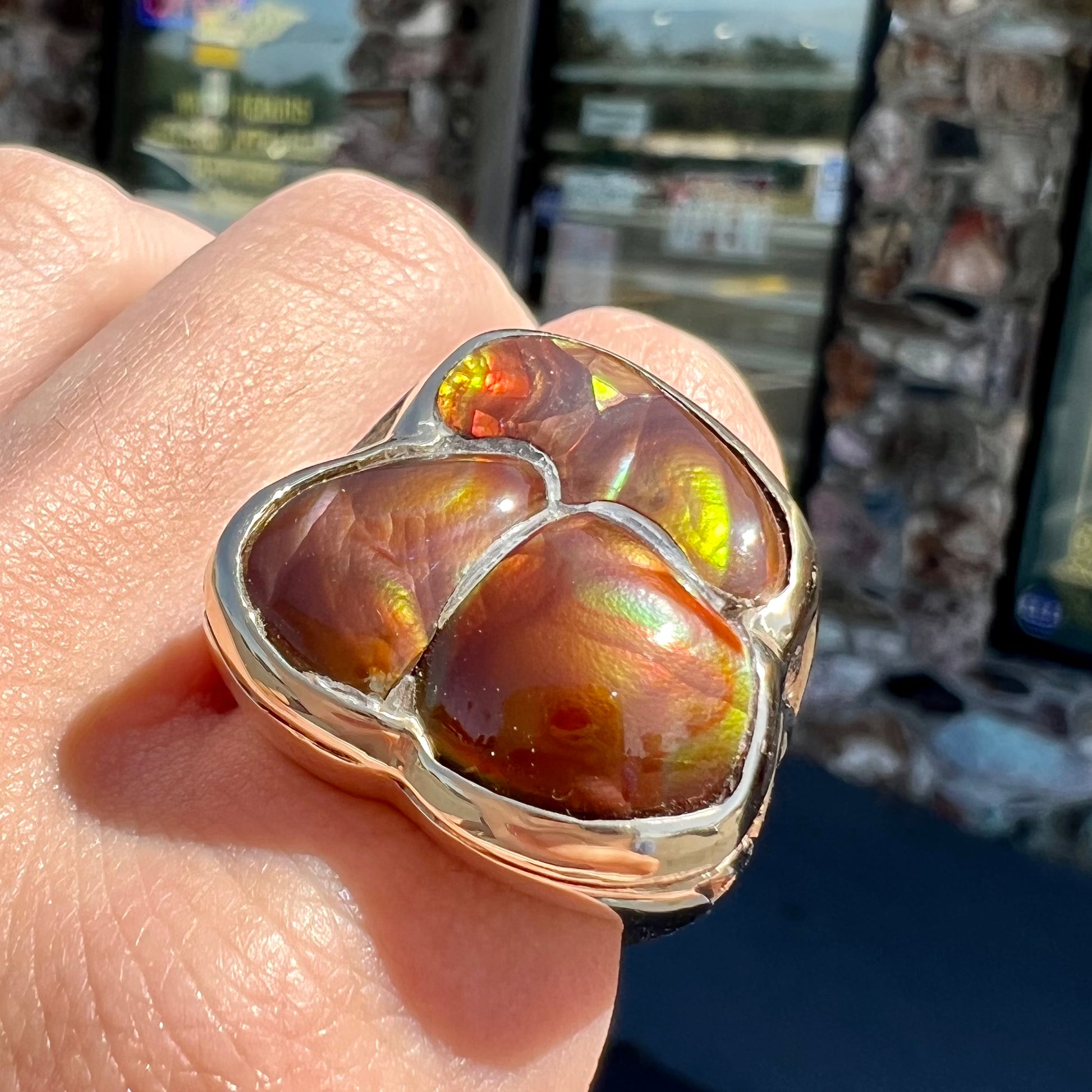 A men's yellow gold ring inlaid with three freeform cut fire agate stones.