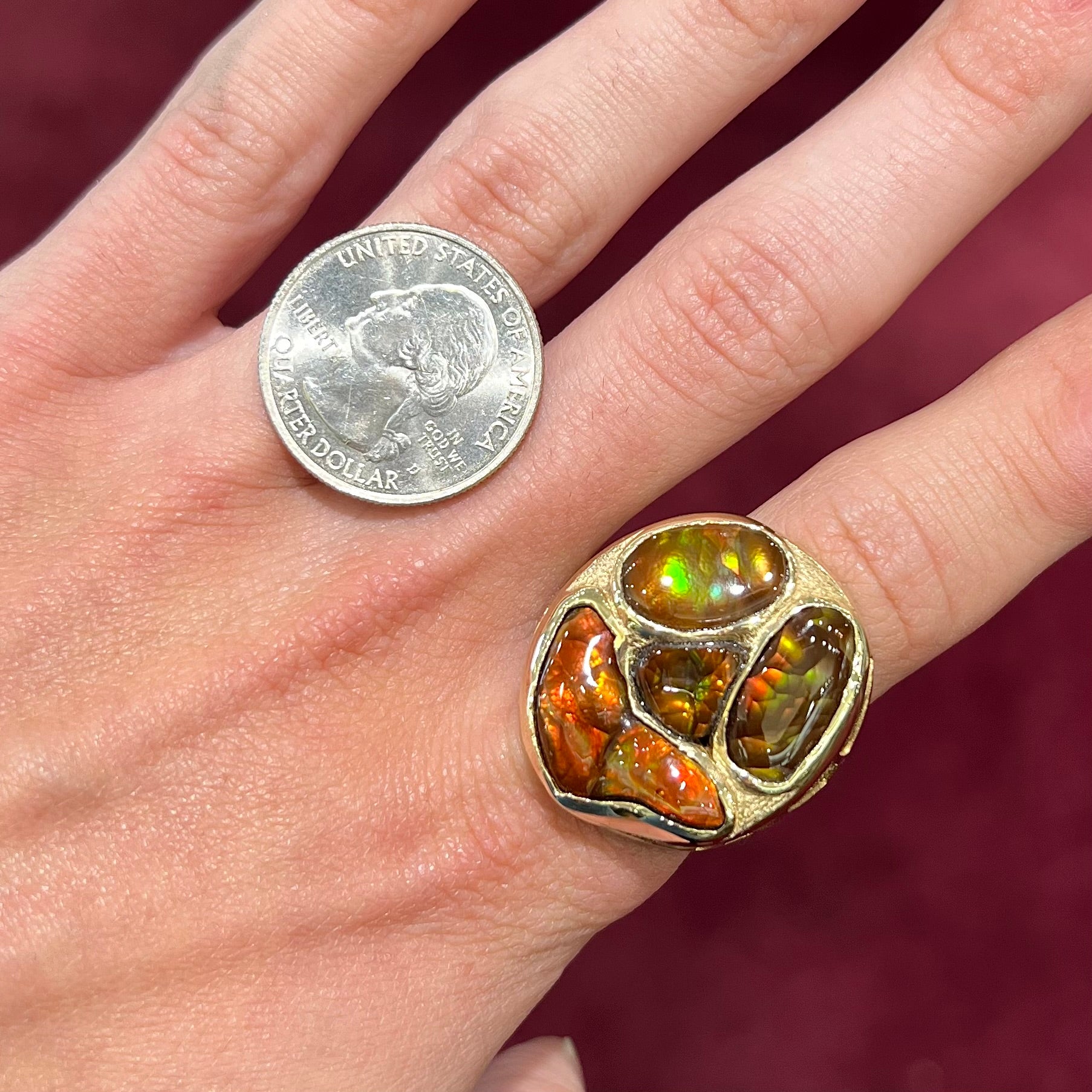A yellow gold men's thug ring set with four fire agate stones resembling a spooky face.