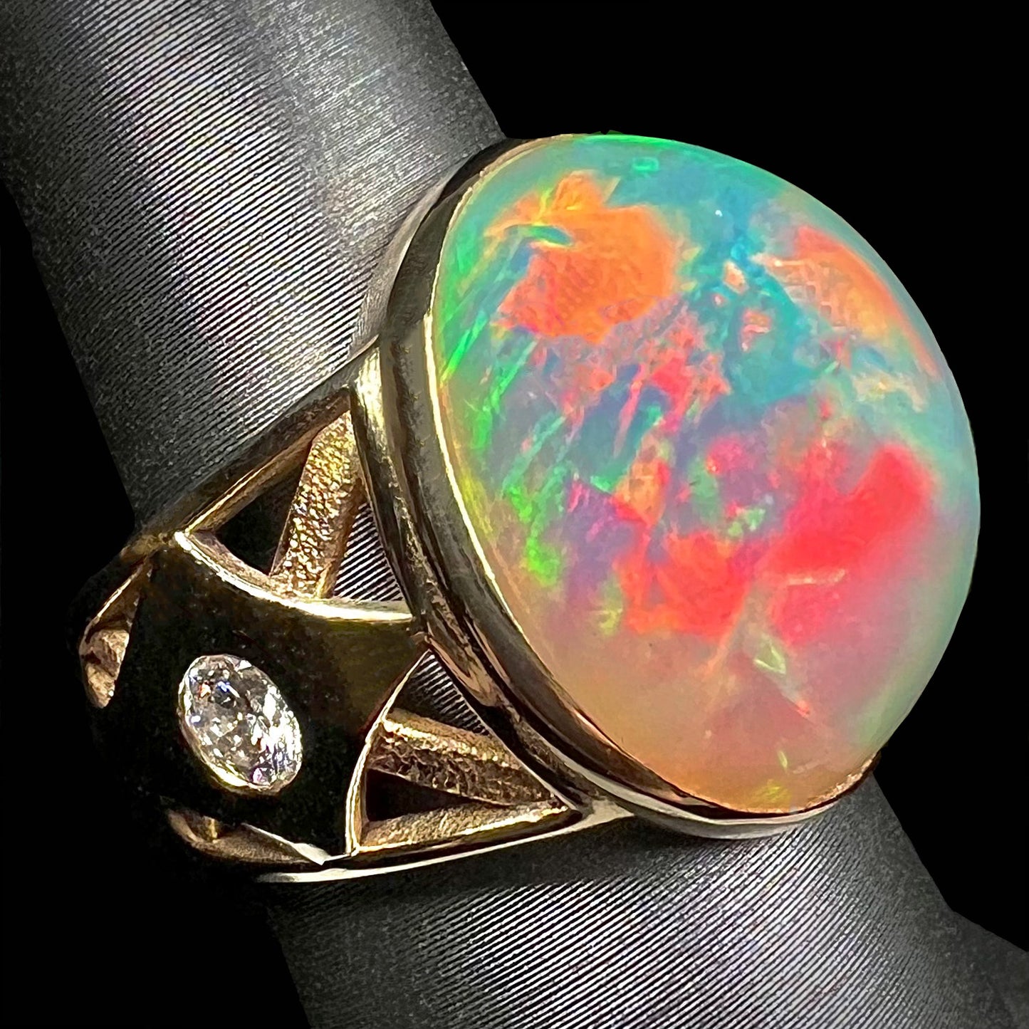 A custom yellow gold men's ring set with two diamonds and a large oval cabochon cut opal from Magdalena, Mexico.