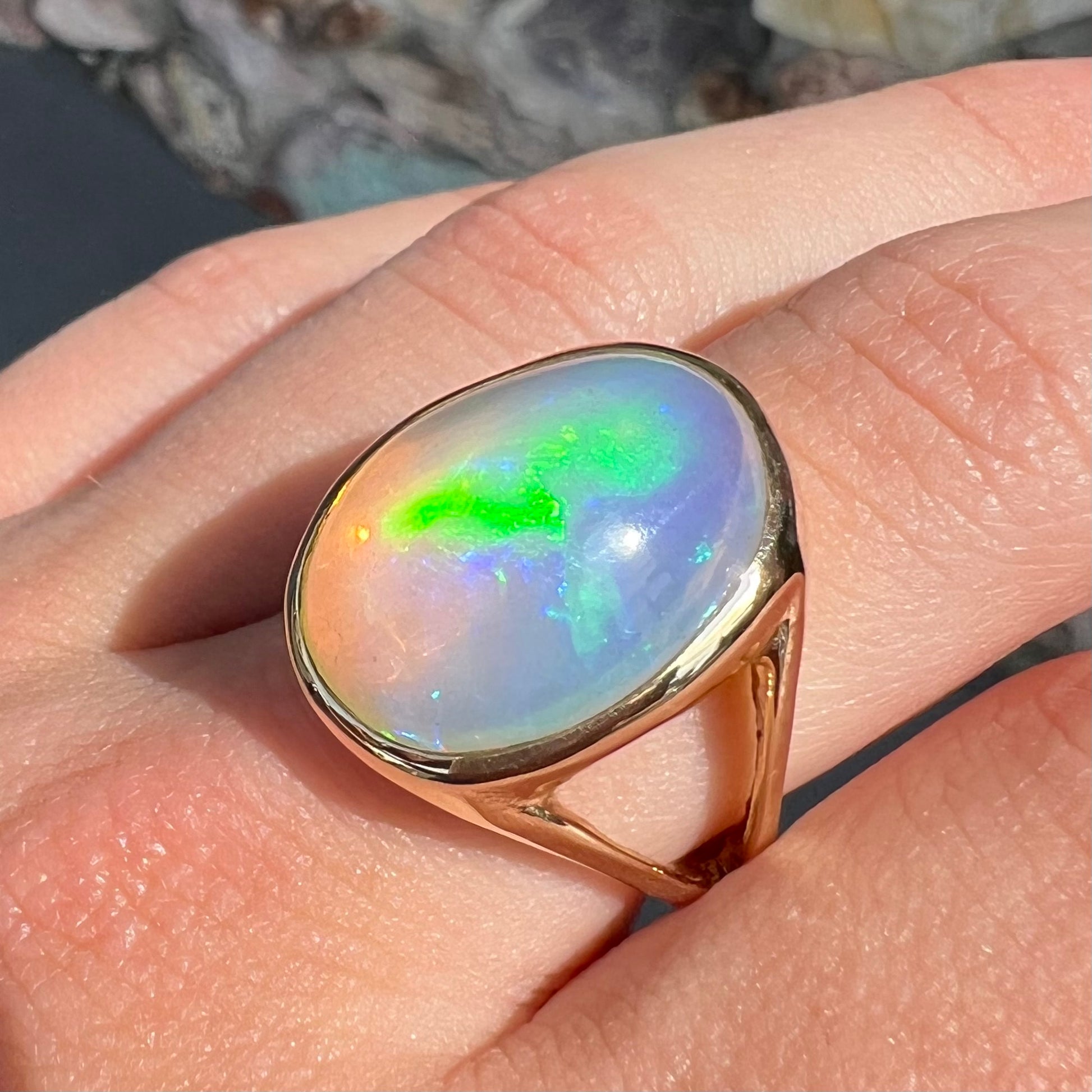 A gold split shank solitaire ring set with an oval cabochon cut 16.83 carat Ethiopian jelly fire opal.