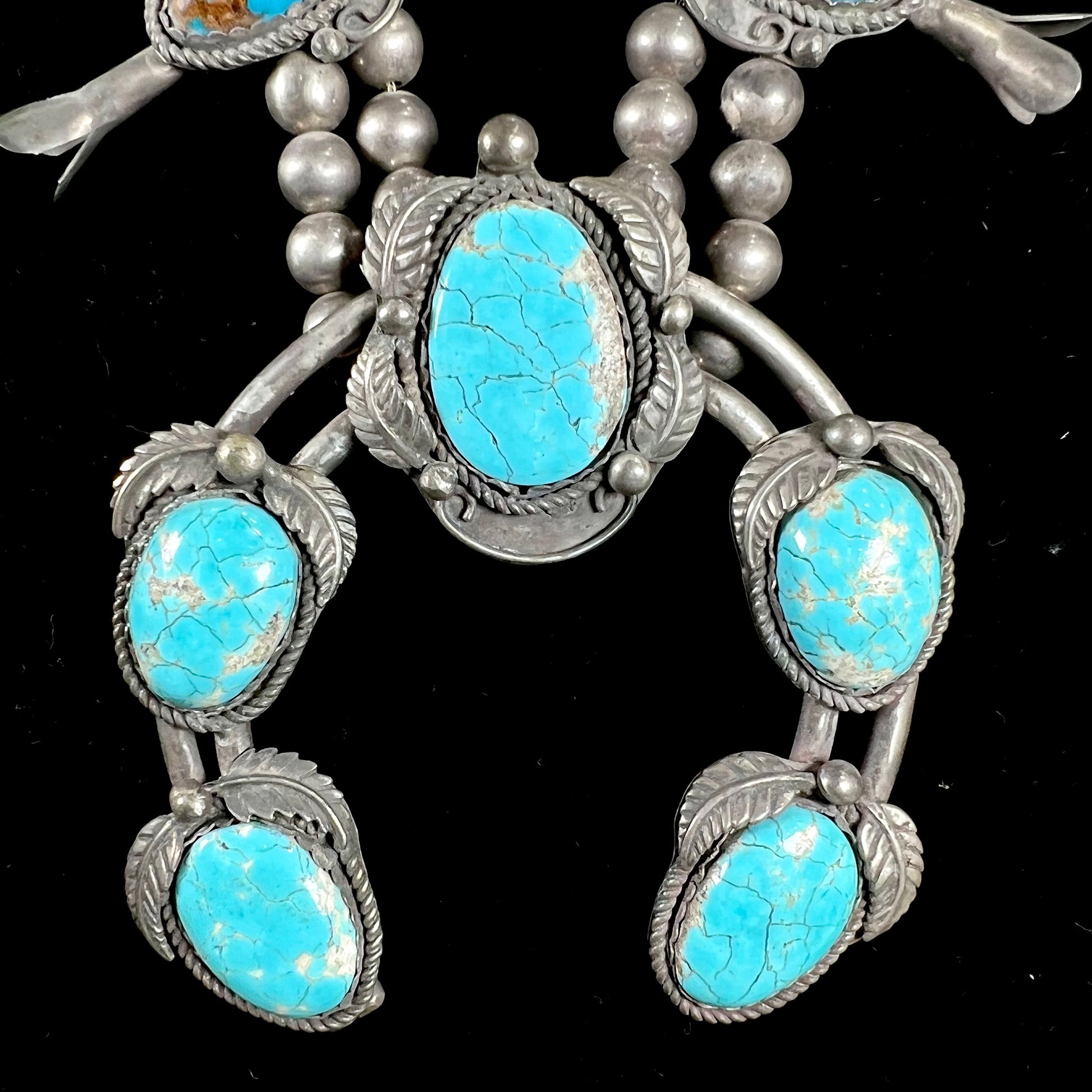 A silver Navajo men's squash blossom necklace set with Fox turquoise and Sonora turquoise.