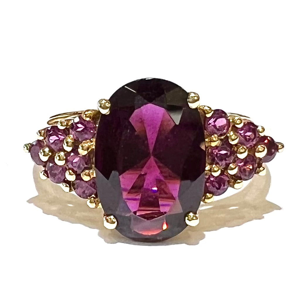 A yellow gold ring with purple prong set rhodolite garnets.