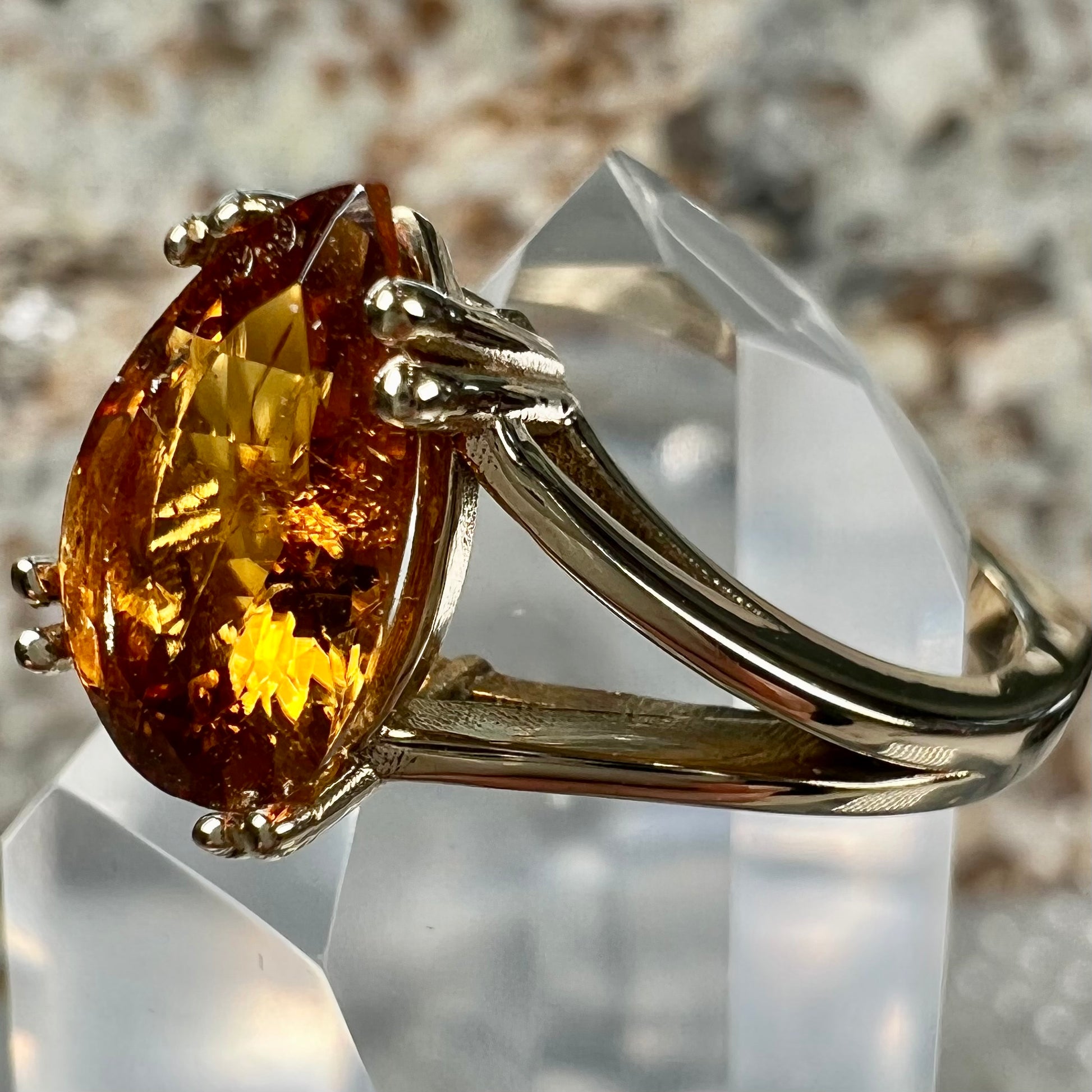 A gold split Euro shank solitaire ring set with an orange pear shape hessonite garnet stone.