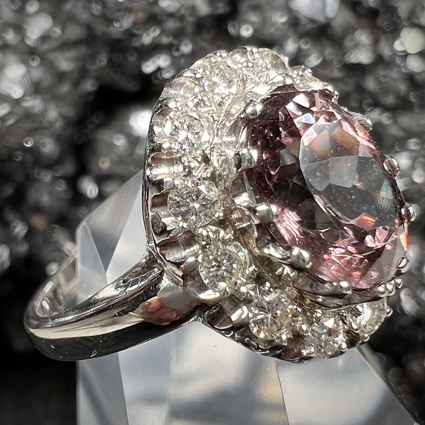 A white gold diamond halo ring set with a purplish faceted oval cut color change garnet.