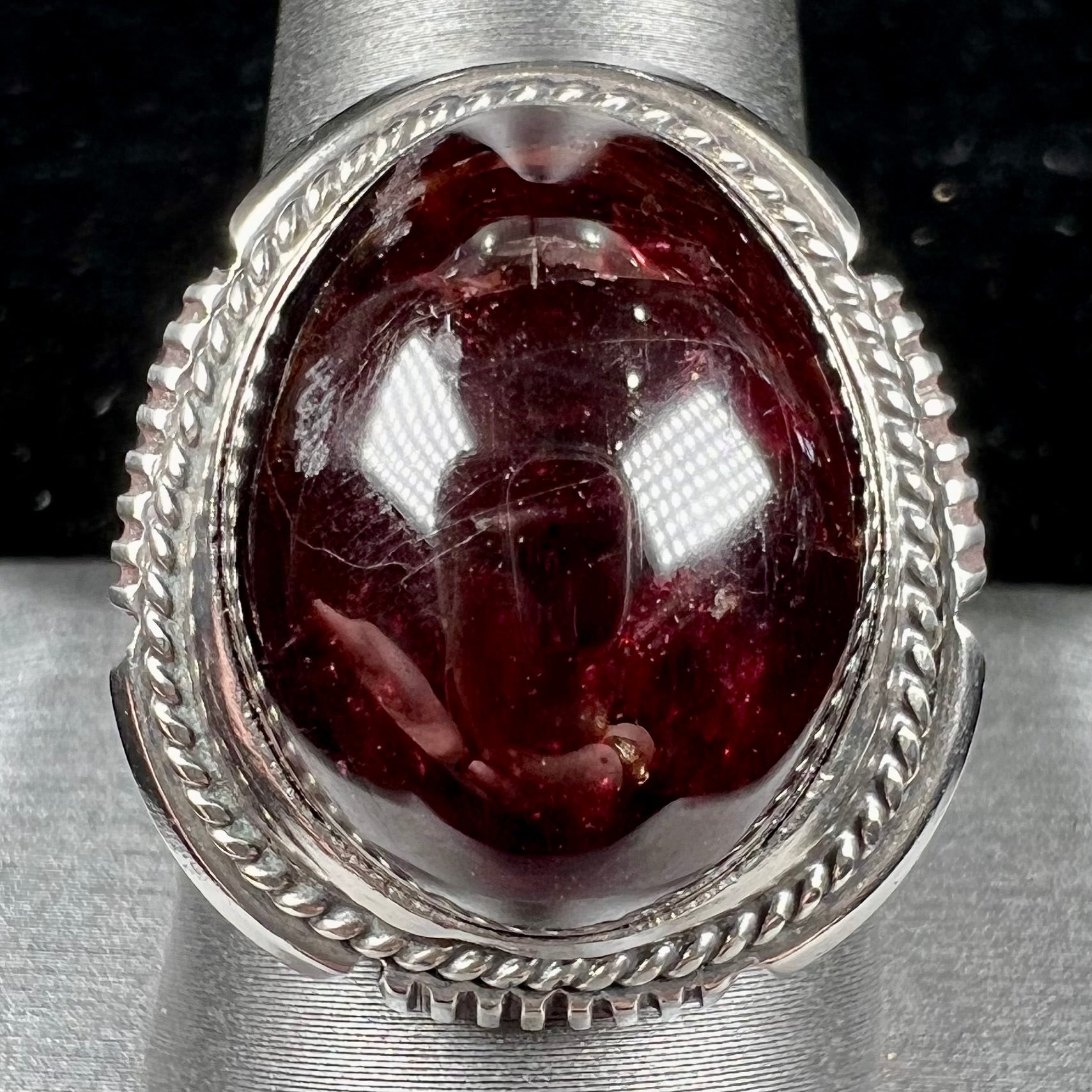 A men's sterling silver garnet ring handmade by Navajo artist Will Denetdale.