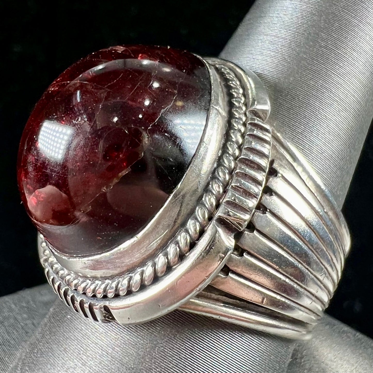 A men's sterling silver garnet ring handmade by Navajo artist Will Denetdale.