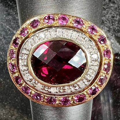 A yellow gold garnet and diamond halo ring set with a checkerboard cut rhodolite garnet center stone.