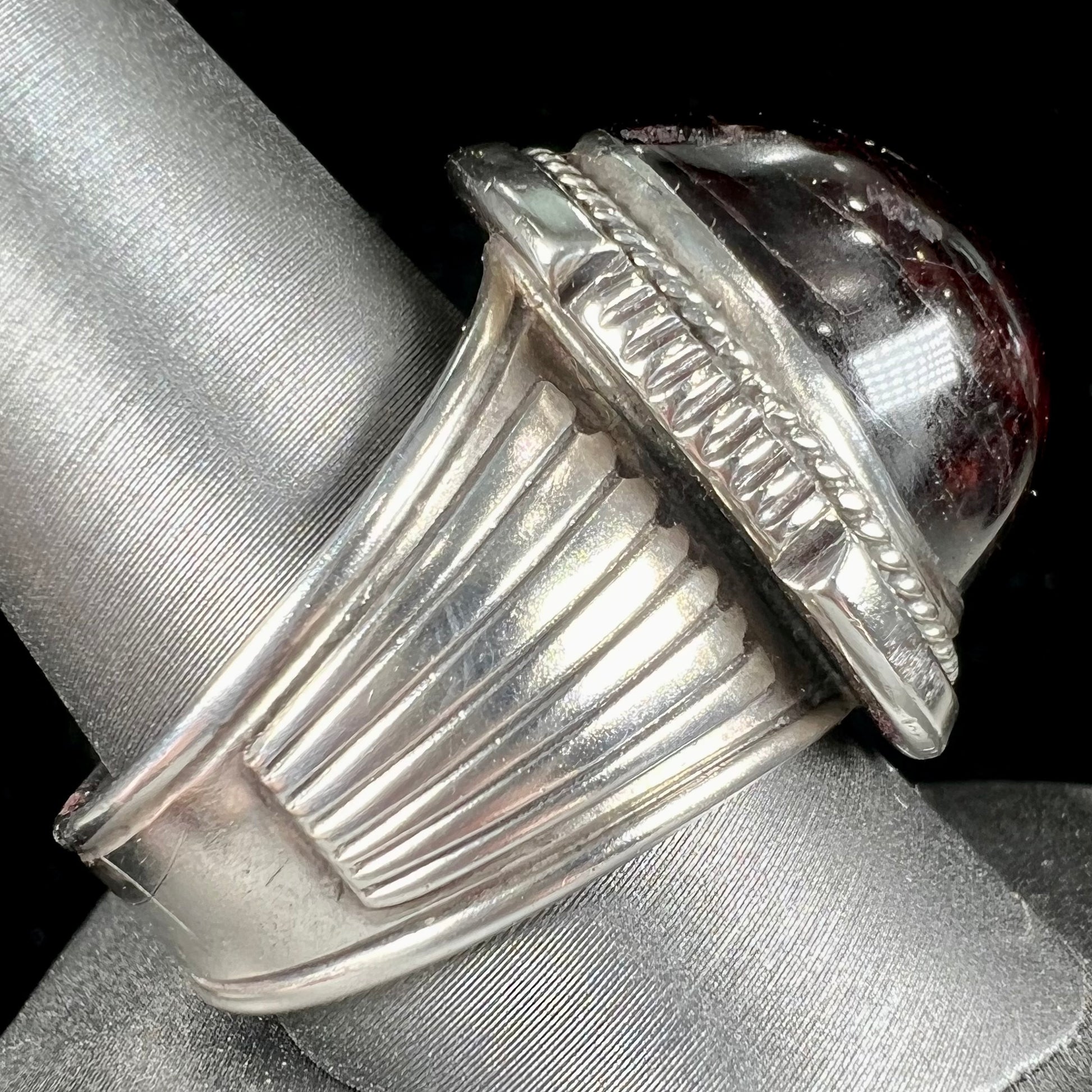 A men's sterling silver garnet ring handmade by Navajo artist Will Denetdale.