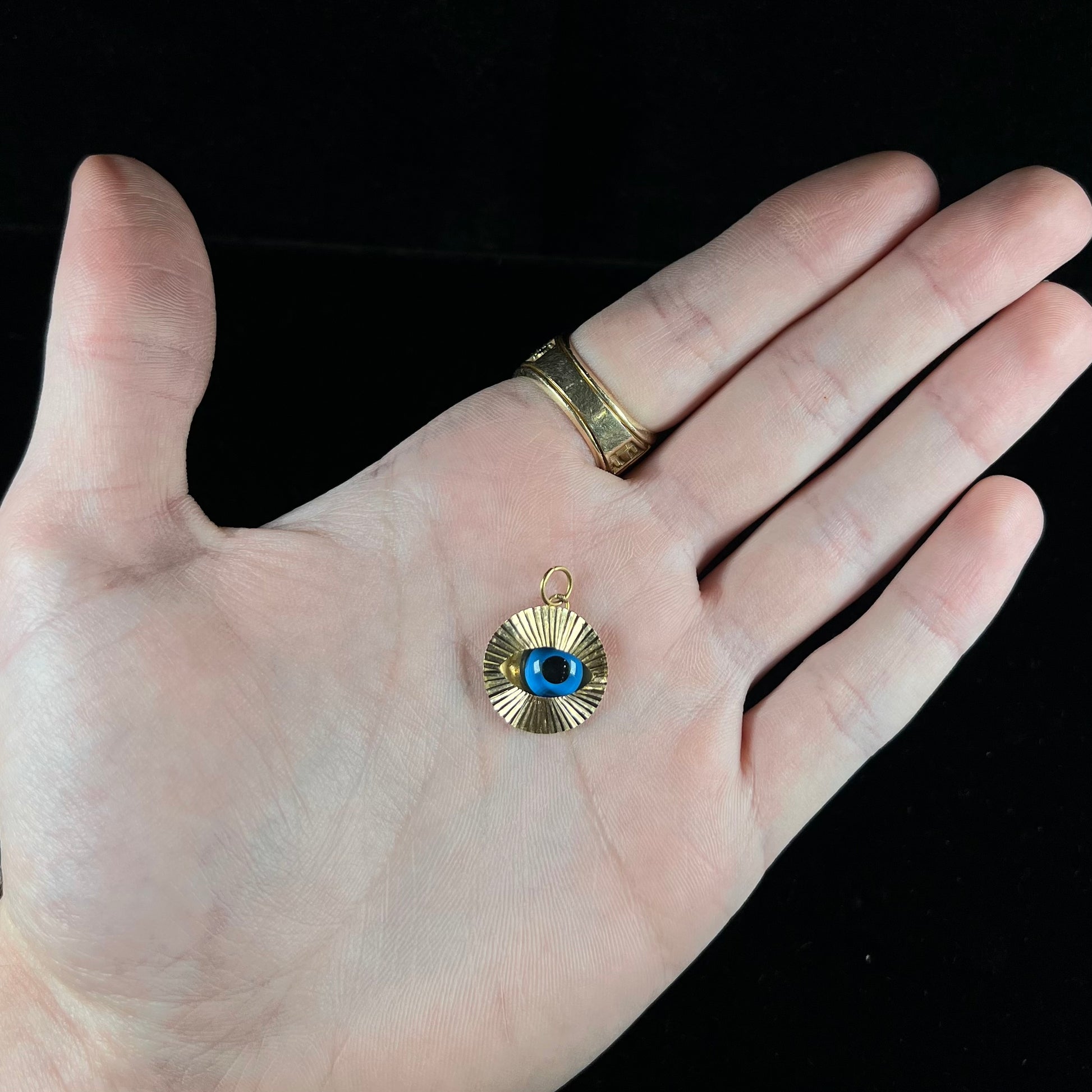 An 18kt yellow gold all-seeing eye pendant with a moving glass eye.