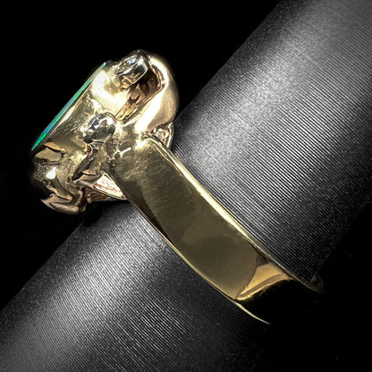 A ladies' yellow gold oval cut natural black opal ring set with five round accent diamonds.