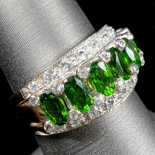 A ladies' two-tone white and yellow gold ring set withseven oval cut chrome diopside stones and cubic zirconia accents.