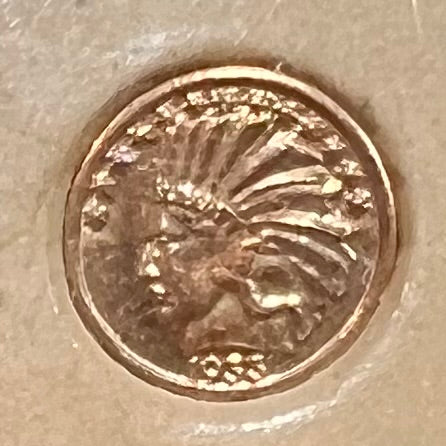 A 14 karat gold miniature commemorative of a 1933 Indian Head Gold Eagle coin.