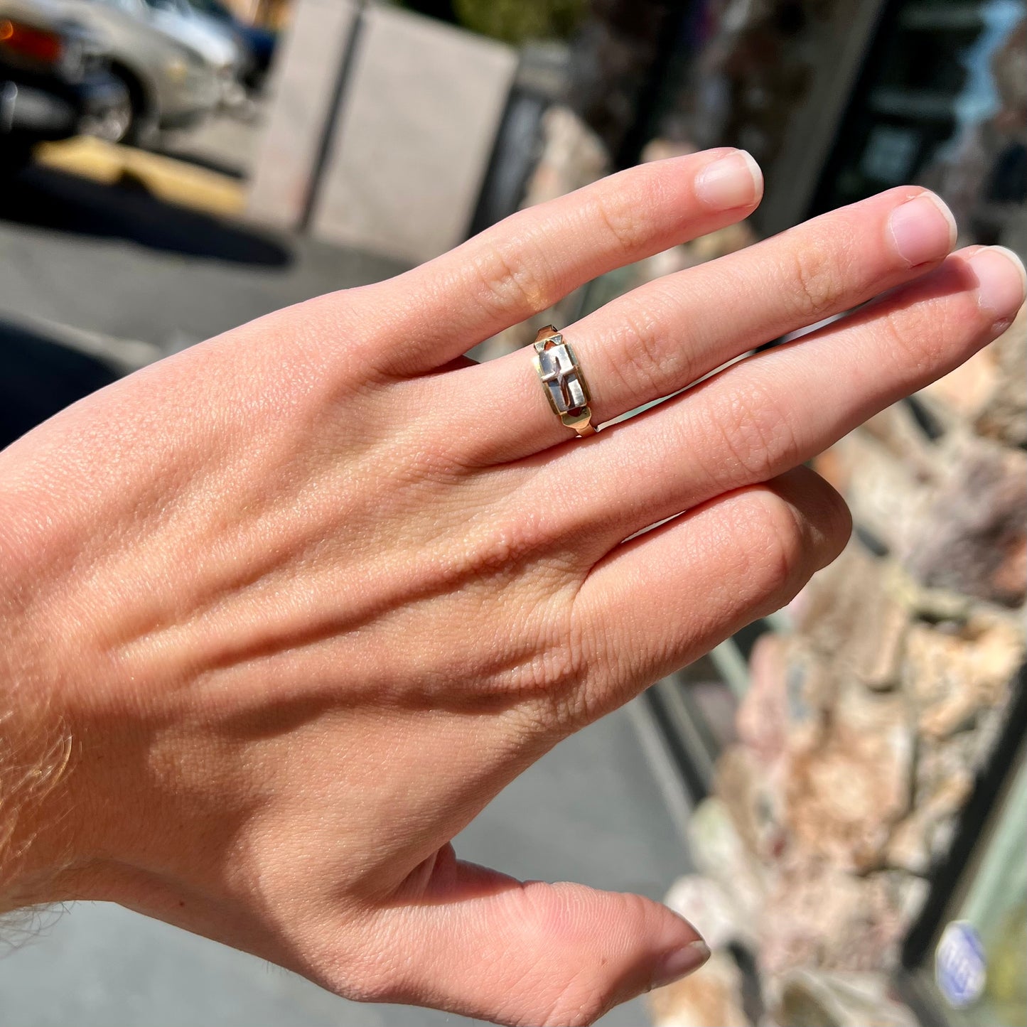 A tricolor gold cross ring handmade from rose, white, and yellow gold.