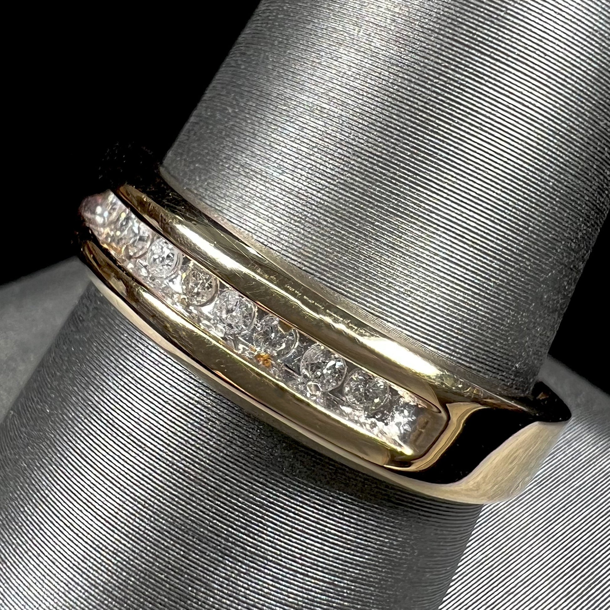 A men's yellow gold channel set diamond wedding band.