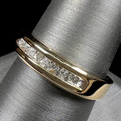 A men's yellow gold channel set diamond wedding band.