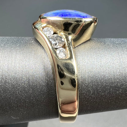 A yellow gold ring set with diamonds and a Lightning Ridge black opal from Australia.