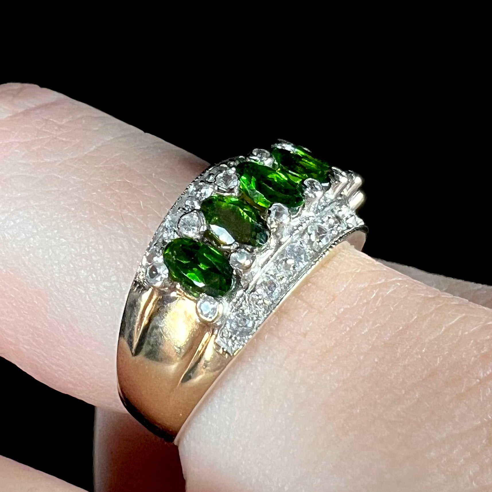 A ladies' two-tone white and yellow gold ring set withseven oval cut chrome diopside stones and cubic zirconia accents.